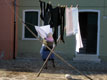 Old Woman Putting Out Linen