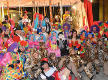 Masked people in Burano in front of a carnival float created by them and representing a circus